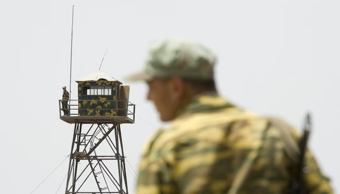 A frontier guard stands on a bridge to Afghanistan across the Panj River in Panji Poyon border outpost, south of Dushanbe, Tajikistan. — Reuters/File