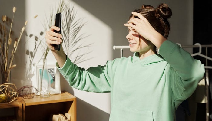 A representational image of a girl taking her selfie. — Canva
