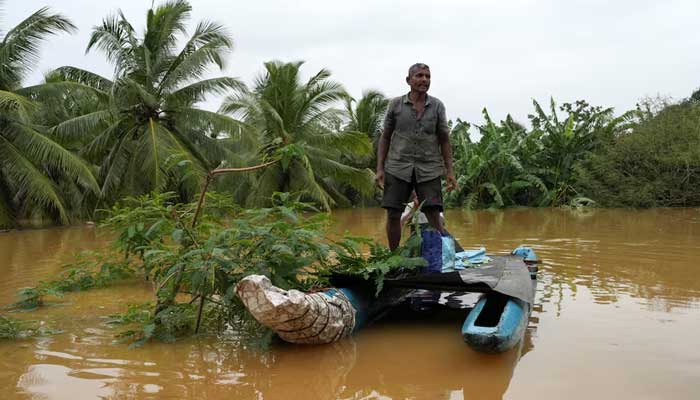 A man stands on a boat at an area affected by flood, following heavy rainfall in Malwana, Sri Lanka on November 29, 2025. — Reuters