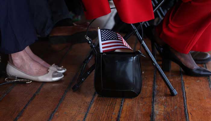 A US flag sticks out from the purse of a citizen candidate attending a US Citizenship and Immigration Services (USCIS) naturalization ceremony aboard the 1885 Tall Ship Wavertree at the South Street Seaport in New York City, US. — Reuters/File