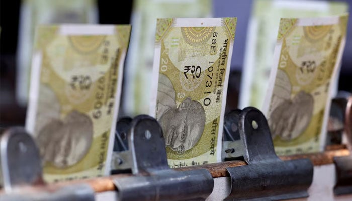Indian twenty rupee currency notes are displayed at a roadside currency exchange stall in New Delhi, India, May 24, 2024. — Reuters