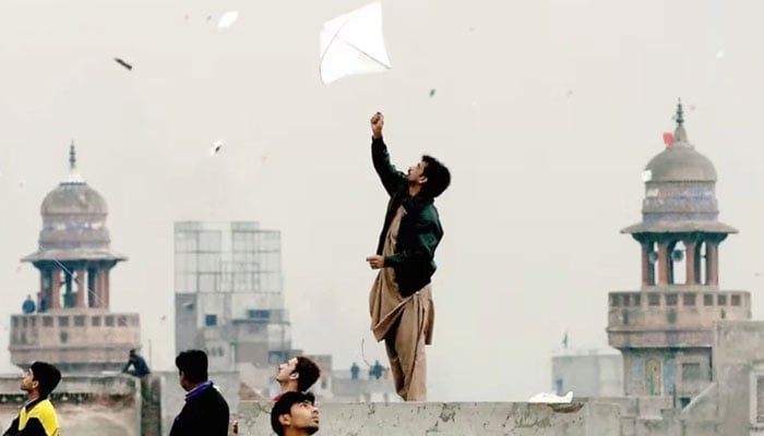 Pakistani youth enjoy flying kites during the Basant or kite flying festival in Lahore on February 6, 2005. — AFP