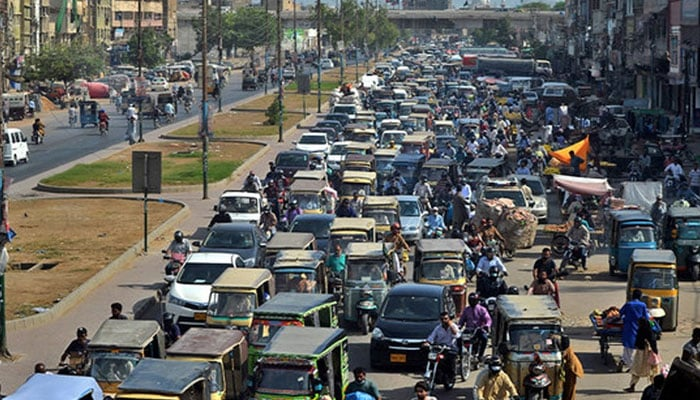 Commuters make their way along a busy road in Karachi on May 11, 2020. — AFP