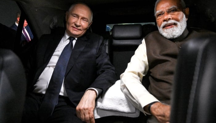 Russian President Vladimir Putin and Indian Prime Minister Narendra Modi sit in a car during a welcoming ceremony at the Palam Air Base in New Delhi, India December 4, 2025. — Reuters
