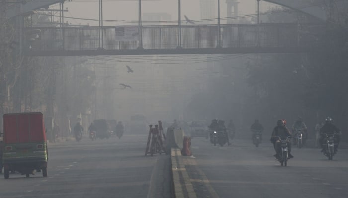 People on their way at a road in Lahore, Punjab. — Online/File
