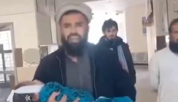 A man carries body of seven-year-old daughter, who died due to the alleged lack of facilities in government hospital located in South Waziristan, Khyber Pakhtunkhwa. — Reporter