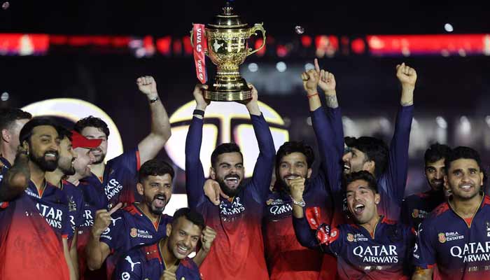 Royal Challengers Bengalurus Virat Kohli lifts the trophy as he celebrates with teammates after winning the Indian Premier League.— Reuters