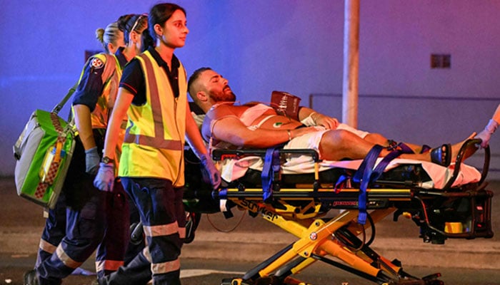 Health workers move a man on a stretcher to an ambulance after a shooting incident at Bondi Beach in Sydney on December 14, 2025. — AFP