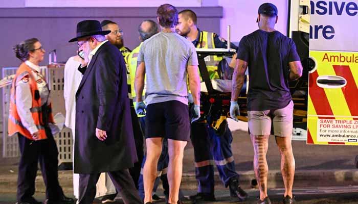 Health workers put a patient into an ambulance after a shooting incident at Bondi Beach in Sydney on December 14, 2025. — AFP