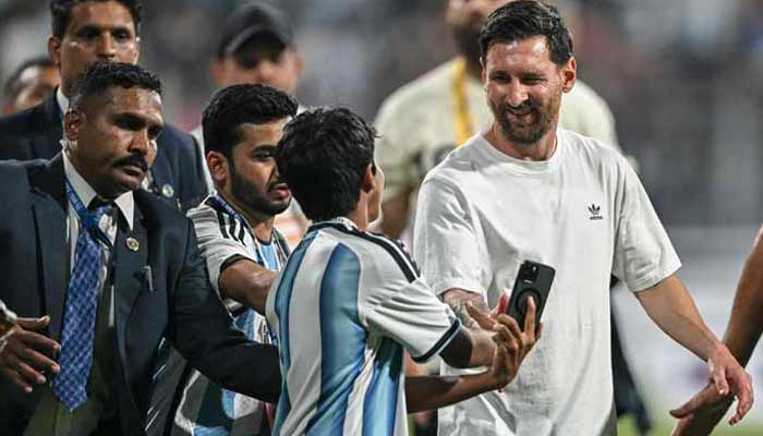 Argentinas footballer Lionel Messi (Right) interacts with a young fan during his Goat Tour at the Wankhede Stadium in Mumbai on December 14, 2025.— AFP