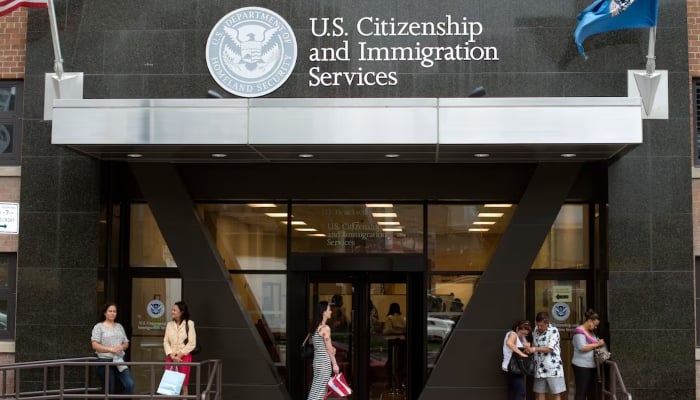 People stand on the steps of the US Citizenship and Immigration Services offices in New York, August 15, 2012. — Reuters