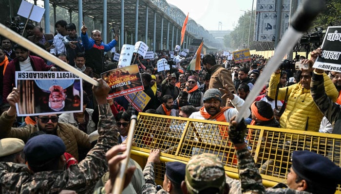 Security personnel try to stop Vishva Hindu Parishad (VHP) activists along with others during a protest march near the Bangladesh High Commission in New Delhi on December 23, 2025. — AFP