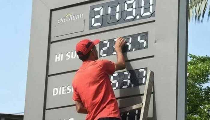A representational image of a fuel station staffer updating the fuel prices in Karachi. — AFP/ File