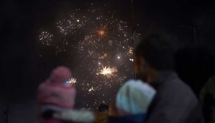 A man watches the fireworks display during the New Year celebrations in Karachi. — AFP/File