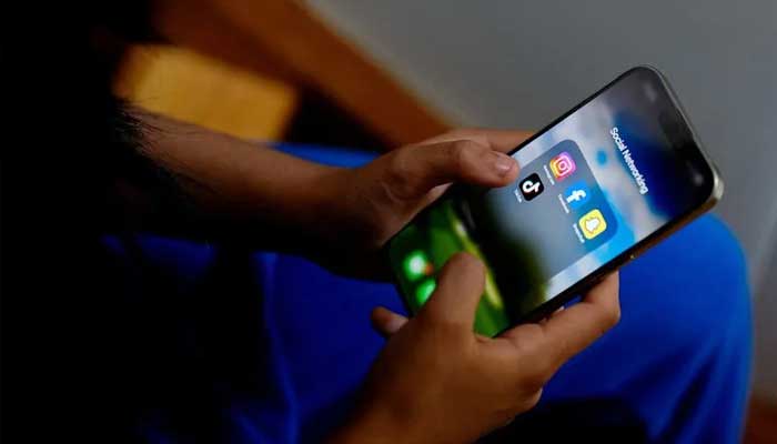 High school student poses with her mobile showing her social media applications in Melbourne. — Reuters/File