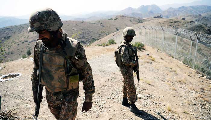 Pakistan Army soldiers patrol next to a newly fenced border fencing along Afghan border at Kitton Orchard Post in North Waziristan. —AFP/File