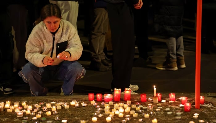 A woman holds a candle outside the Le Constellation bar, after a fire and explosion during a New Year’s Eve party where several people died and others were injured, according to Swiss police, in the upscale ski resort of Crans-Montana in southwestern Switzerland, January 1, 2026. — Reuters