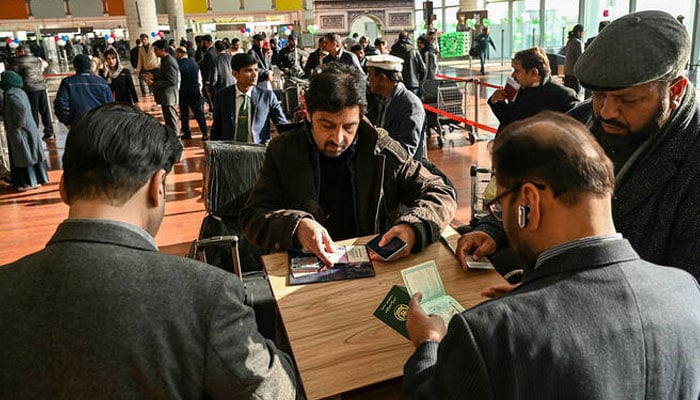 Immigration officers check documents of passengers before boarding their Pakistan International Airlines (PIA) flight to Paris at the Islamabad International Airport on January 10, 2025. — AFP