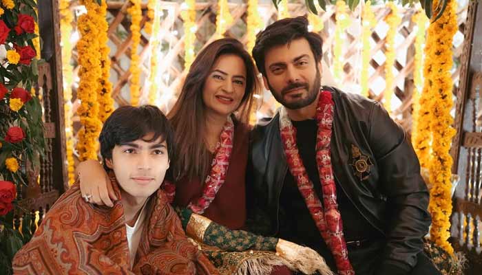 Actor Fawad Khan poses with wife and son on stage while celebrating his 21st wedding anniversary. — Instagram/@Kismatt
