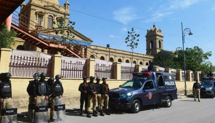 Policemen stand guard outside a polling station during Pakistan’s national elections in Karachi on February 8, 2024. — AFP