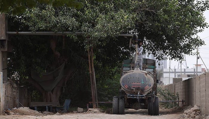 A man fills a water tanker from an illegal hydrant to provide water to residential areas in Karachi. — AFP/File