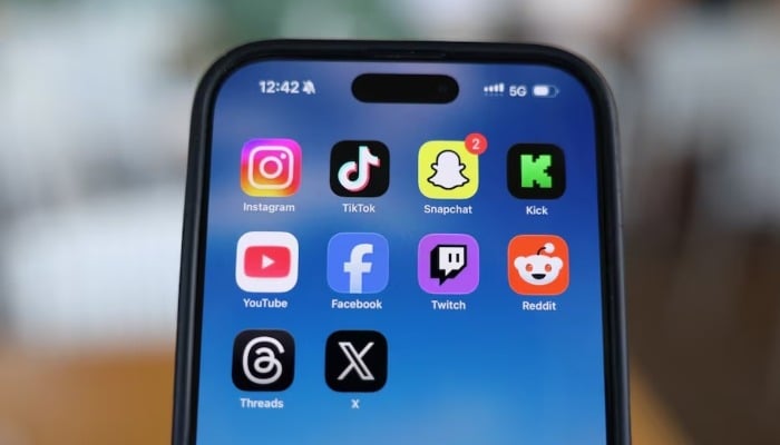 Instagram, TikTok, Snapchat, Kick, YouTube, Facebook, Twitch, Reddit, Threads and X applications are displayed on a mobile phone in this picture illustration. — Reuters