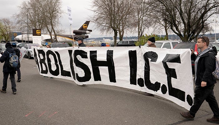 People hold a banner during a protest against deportation flights at King County International Airport, which is used by US Immigration and Customs Enforcement (ICE), in Seattle, Washington, US, January 15, 2026. — Reuters