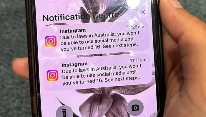 A smartphone screen showing notifications on Instagram about suspension of an underage account. — AFP