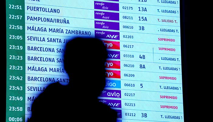 A person walks past an information board at the Atocha train station, amid train delays and cancellations, following a deadly derailment of two high-speed trains in Adamuz near, Cordoba, according to local police reports, in Madrid, Spain, January 18, 2026. — Reuters