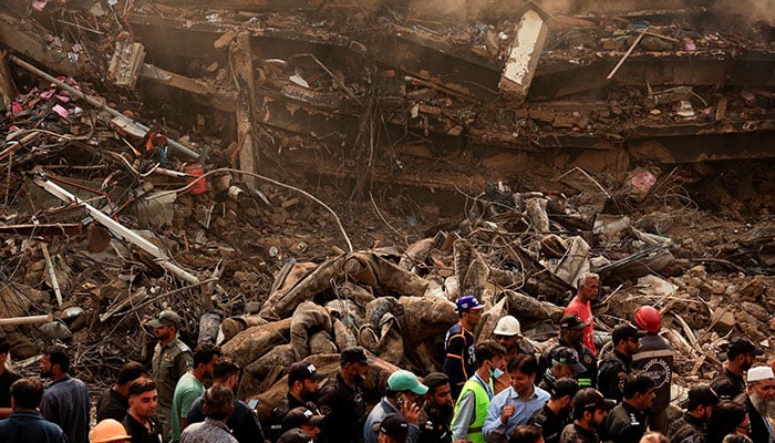 Police officers, rescue workers and shopkeepers gather, following a massive fire that broke out in the Gul Plaza Shopping Mall in Karachi on January 19, 2026. &mdash; Reuters