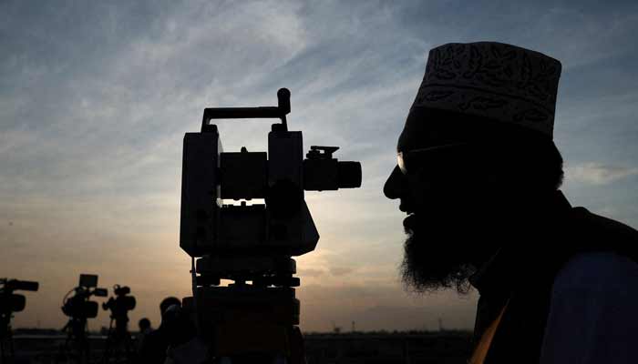 A member of Pakistans moon sighting committee is silhouetted as he uses theodolite to look for the new moon in Peshawar, Pakistan. — Reuters/File