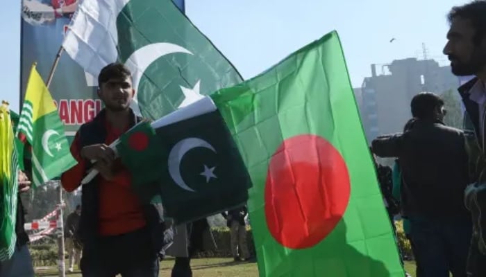 Vendor sells Pakistan’s and Bangladesh’s flags outside Gadaffi Stadium ahead of a cricket match. — AFP