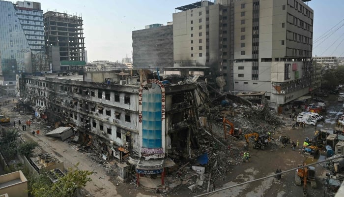Workers clear debris after a massive fire broke out at a shopping mall in Karachi on January 22, 2026. — AFP