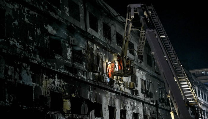 Rescue workers search for bodies among the rubble after a massive fire broke out at a shopping mall in Karachi on January 21, 2026. — AFP
