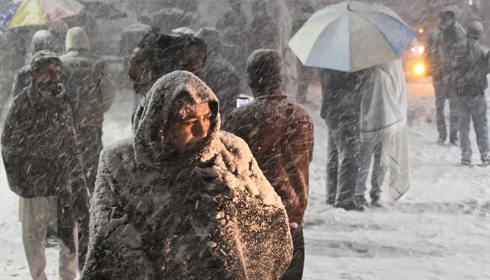 A citizen is blanketed during a snowstorm in Murree on January 23, 2026. — AFP