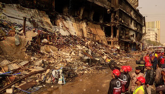 Emergency personnel survey the damaged portion of the building, following a massive fire that broke out in the Gul Plaza shopping centre in Karachi on January 19, 2026. — Reuters