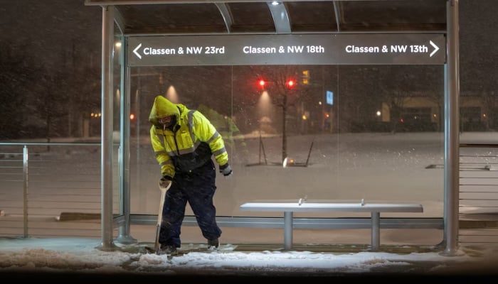 A maintenance worker clears snow from a bus stop as Winter Storm Fern arrives in Oklahoma City, Oklahoma, US, January 23, 2026. — Reuters