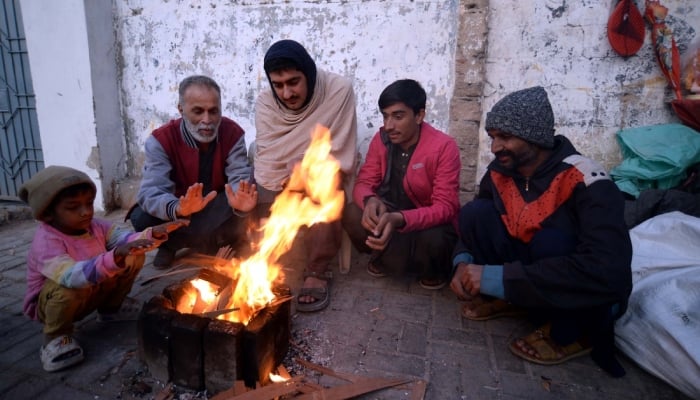 People warm their hands on bonfire to stay safe from chilly weather in Karachi on January 23, 2026. — PPI