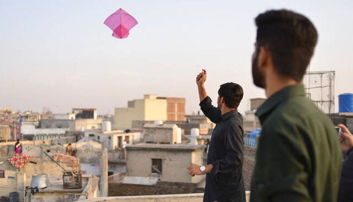 A person flies kite on a rooftop during the Basant festival in Rawalpindi on February 18, 2022. — AFP