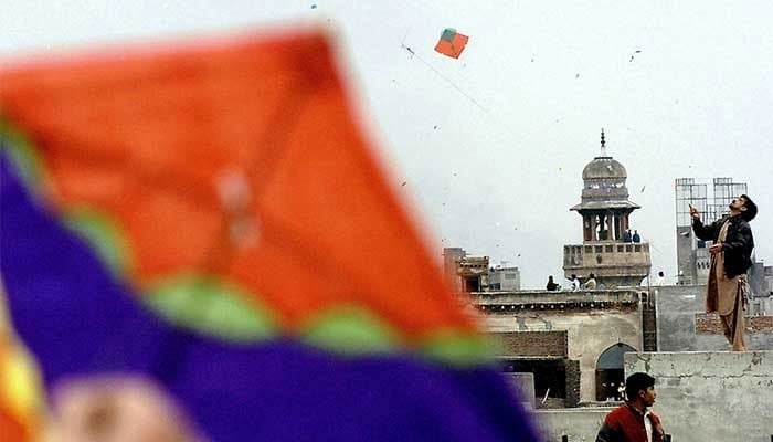 Pakistani youths enjoy flying kites during the Basant or kite flying festival in Lahore, February 6, 2005. — AFP