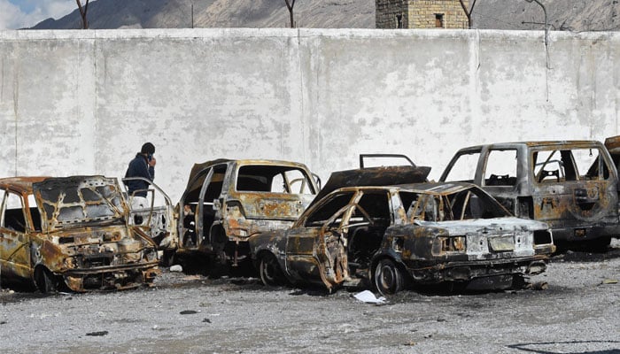 A man walks past burnt vehicles in a torched police station on the outskirts of Quetta on February 1, 2026 a day after an attack by Baloch separatists. — AFP