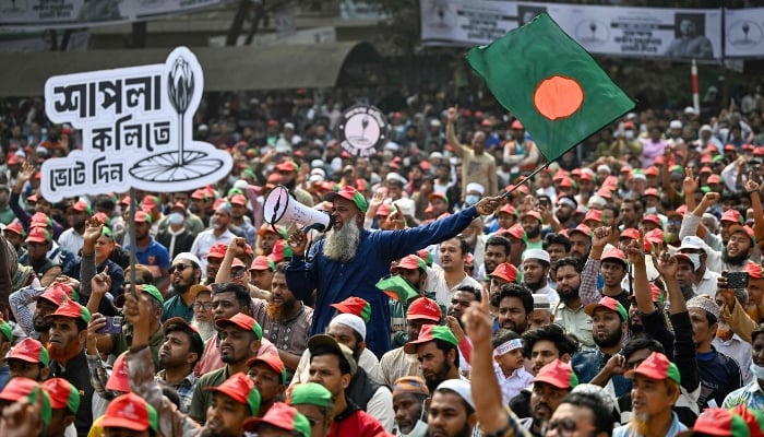 Jamaat-e-Islami party-led alliance supporters wave Bangladeshs national flag during a rally ahead of the countrys general election in Dhaka on February 8, 2026. — AFP