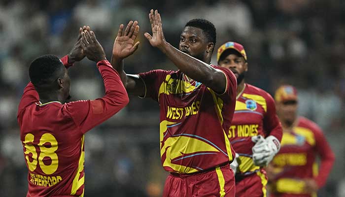 West Indies Romario Shepherd (C) celebrates with teammates after taking the wicket of Englands Phil Salt during the 2026 ICC Mens T20 Cricket World Cup group stage match between England and West Indies at the Wankhede Stadium in Mumbai on February 11, 2026. — AFP