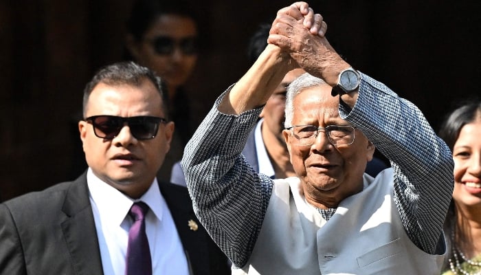 Chief Adviser of Bangladesh´s Interim Government, Muhammad Yunus (R) gestures as he arrives to cast his ballot at a polling station during Bangladesh´s general election in Dhaka on February 12, 2026. — AFP