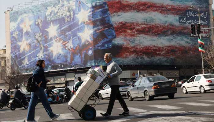 People walk past an anti-US billboard in Tehran, Iran, February 19, 2026. — Reuters