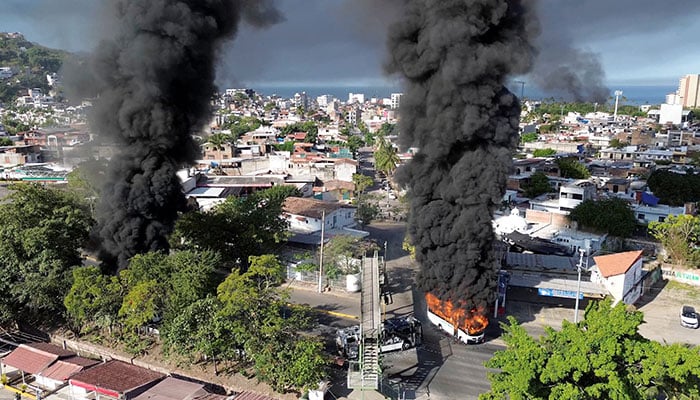 Smoke billows from burning vehicles following a military operation in which a government source said Mexican drug lord Nemesio Oseguera, known as El Mencho, was killed, in Puerto Vallarta, Jalisco, Mexico on February 22, 2026. — Reuters