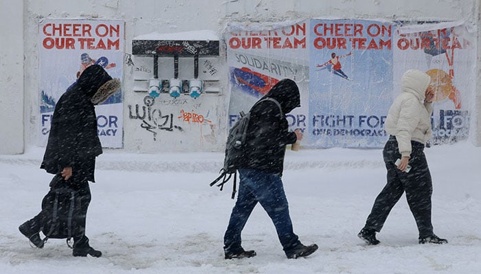 Pedestrians walk through a winter blizzard snow storm in Boston, Massachusetts, US, February 23, 2026. — Reuters