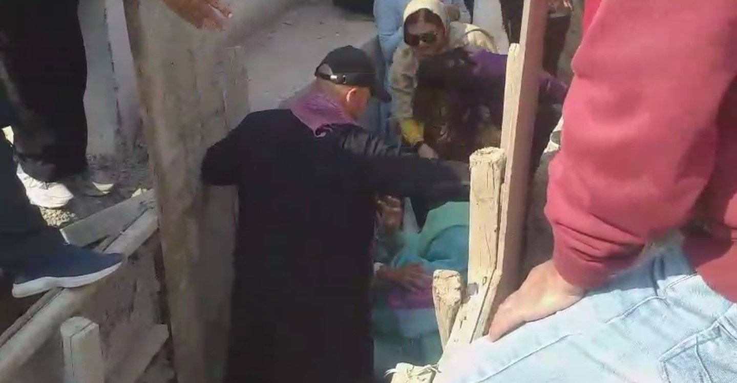 A screengrab taken from a video shows people trying to pull out Noreen Niazi from under-construction sewerage line. — Geo News