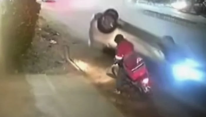 A speeding car overturned and crashed into the food delivery rider in Khayaban-e-Ittehad, Defence Housing Authority (DHA), Karachi. — Screengrab via YouTube/Geo News