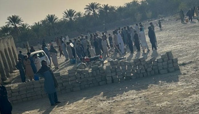 A large number of people gather outside a house following violent attack in Buleda area of Turbat, where unknown assailants opened fire, leaving six dead and two injured, February 25, 2026. — Geo News
